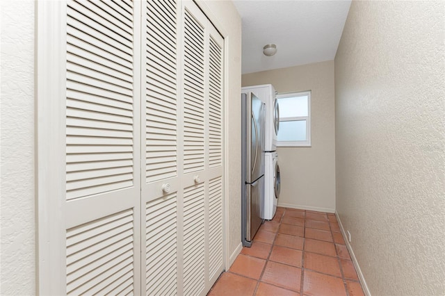 hallway with tile patterned flooring and stacked washing maching and dryer