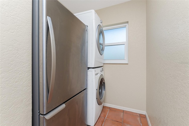 laundry room with stacked washer / dryer and tile patterned flooring