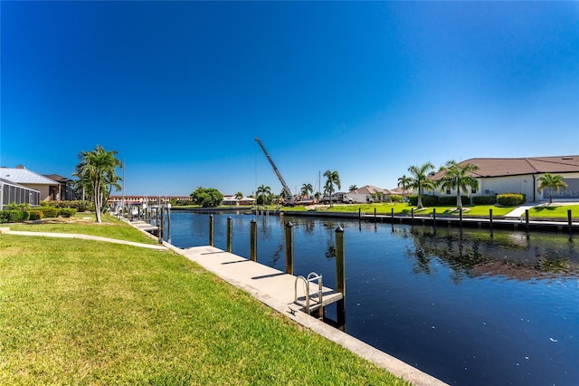 view of dock featuring a water view and a yard