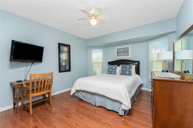 bedroom with dark hardwood / wood-style flooring and ceiling fan