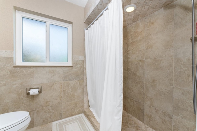 bathroom with a shower with shower curtain and toilet