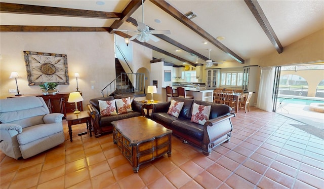 living room with vaulted ceiling with beams, light tile patterned floors, and ceiling fan