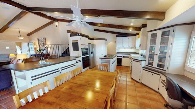 kitchen featuring white cabinetry, stainless steel appliances, a center island, and sink