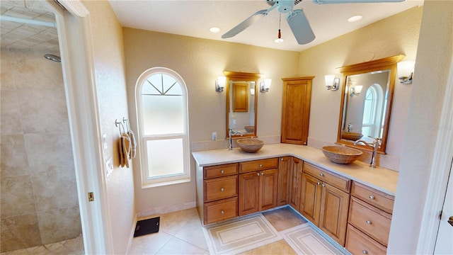 bathroom featuring ceiling fan, tiled shower, vanity, and tile patterned flooring