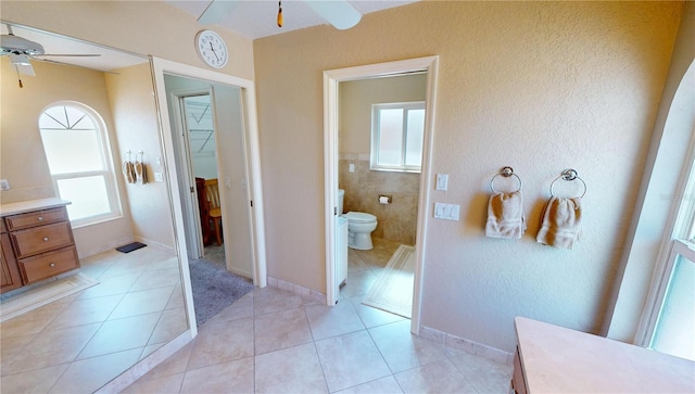 bathroom featuring a wealth of natural light, ceiling fan, and toilet