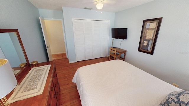 bedroom with hardwood / wood-style floors, ceiling fan, and a closet