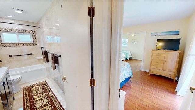 bathroom featuring vanity, a healthy amount of sunlight, hardwood / wood-style floors, and toilet