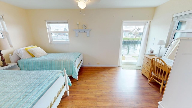 bedroom with multiple windows, access to exterior, and light hardwood / wood-style flooring