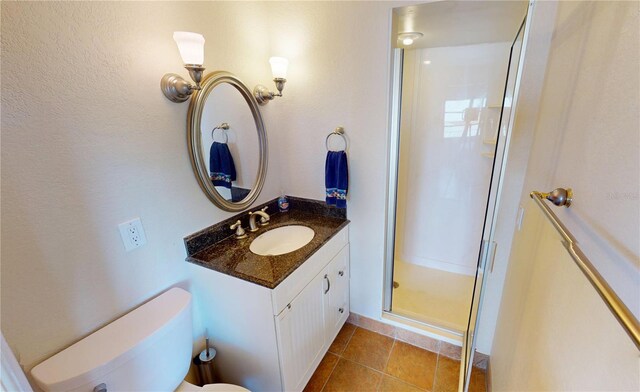 bathroom featuring vanity, tile patterned flooring, toilet, and walk in shower