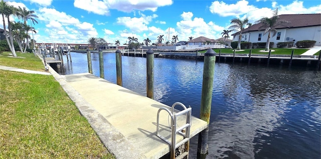 view of dock featuring a lawn and a water view