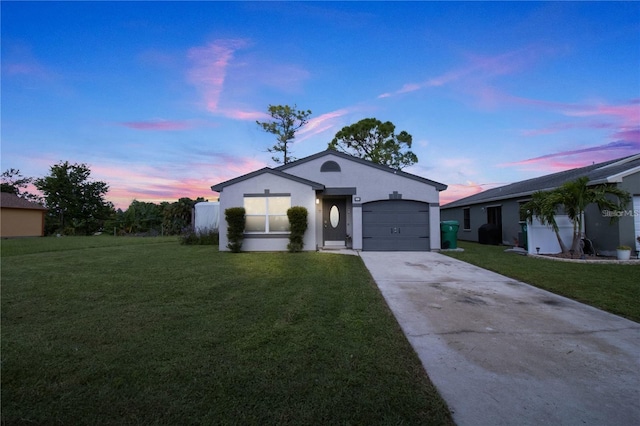 ranch-style house featuring driveway, stucco siding, a garage, and a front yard