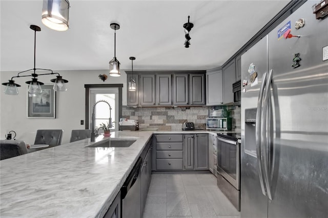 kitchen featuring decorative backsplash, sink, stainless steel appliances, and gray cabinetry