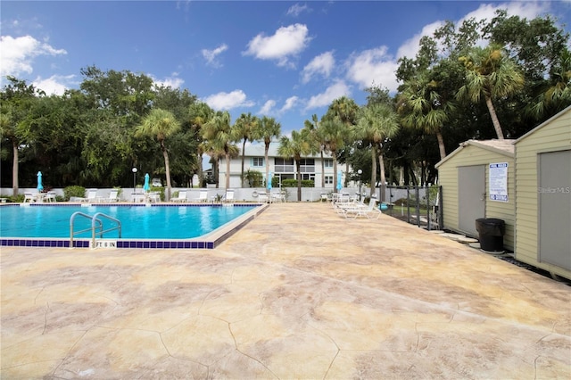 pool with a patio and fence