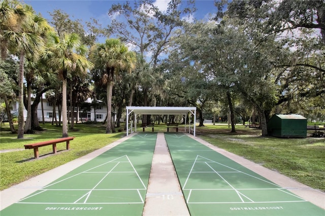 view of community featuring shuffleboard and a lawn