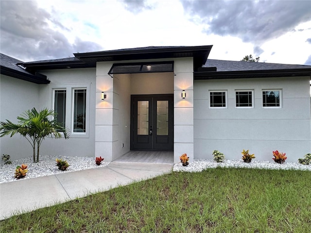 property entrance featuring a yard and french doors