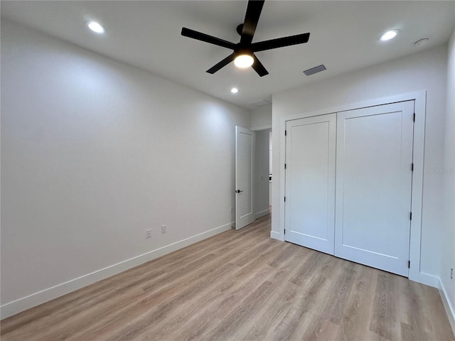 unfurnished bedroom with light wood-type flooring, ceiling fan, and a closet