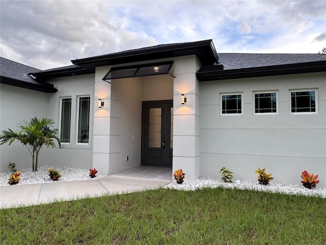 entrance to property with a lawn