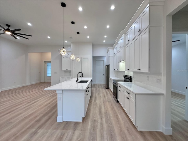 kitchen with ceiling fan, a kitchen island with sink, light wood-type flooring, and electric range