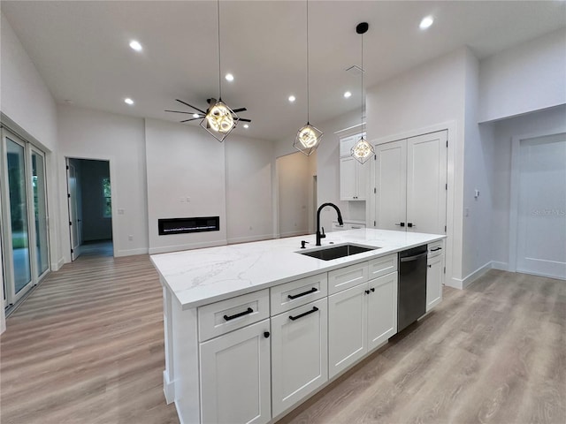 kitchen featuring ceiling fan, white cabinets, an island with sink, sink, and light hardwood / wood-style flooring