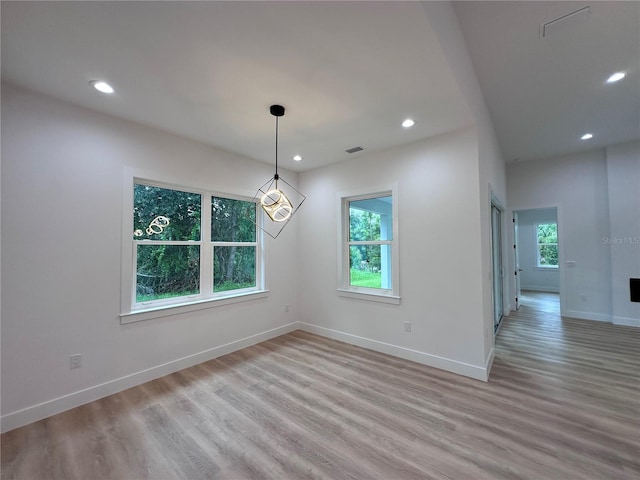 empty room featuring a wealth of natural light and hardwood / wood-style floors