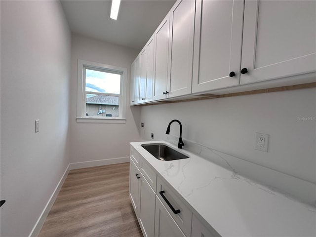 washroom with cabinets, washer hookup, sink, electric dryer hookup, and light hardwood / wood-style flooring