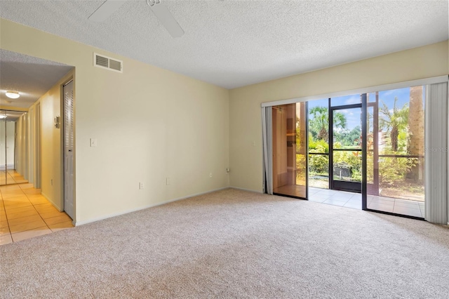 carpeted empty room with ceiling fan and a textured ceiling