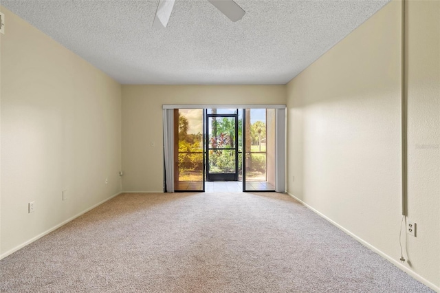 carpeted empty room with ceiling fan and a textured ceiling