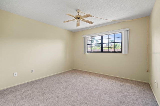 spare room featuring ceiling fan, light carpet, and a textured ceiling