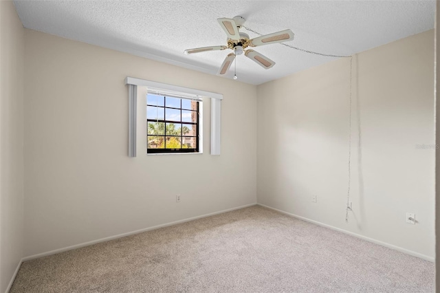 spare room featuring a textured ceiling, light colored carpet, and ceiling fan