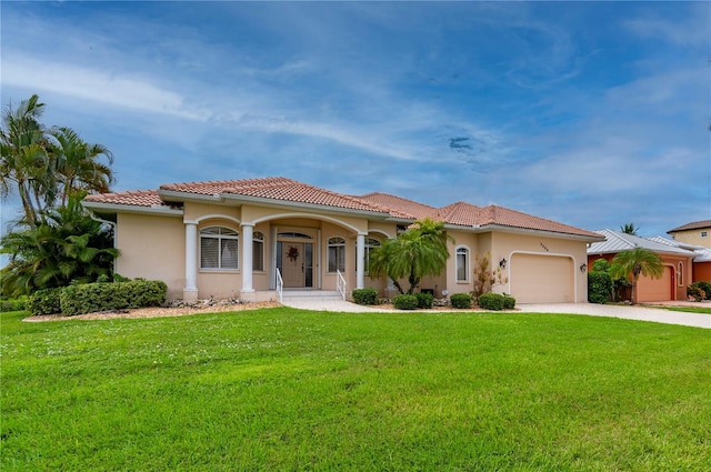 mediterranean / spanish-style house with an attached garage, driveway, a front lawn, and stucco siding