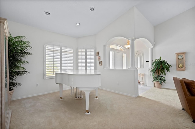 sitting room featuring recessed lighting, light colored carpet, baseboards, vaulted ceiling, and decorative columns