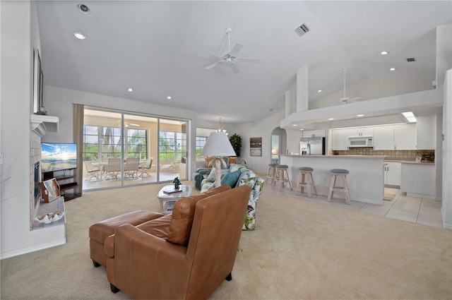 living room featuring ceiling fan, light colored carpet, lofted ceiling, and a fireplace