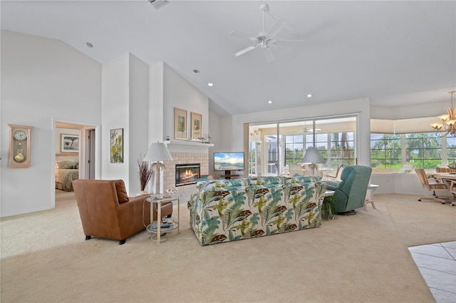 living room with a tile fireplace, ceiling fan with notable chandelier, light carpet, and high vaulted ceiling