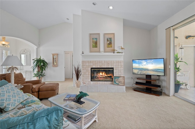 carpeted living room featuring lofted ceiling and a fireplace