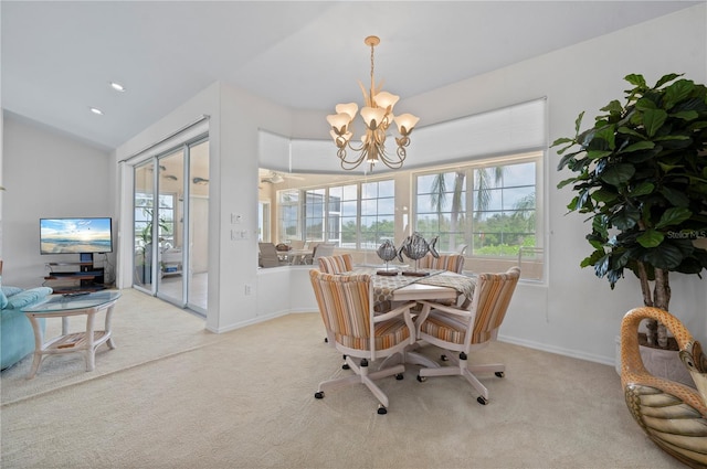 carpeted dining area featuring lofted ceiling and a chandelier