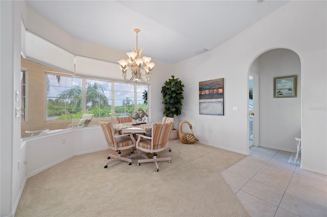 dining room with light carpet and a chandelier