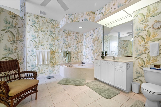 bathroom featuring ceiling fan, vanity, a washtub, tile patterned floors, and toilet