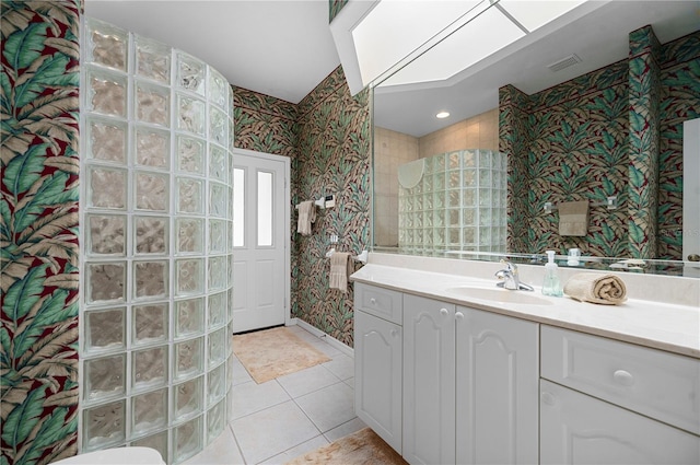 bathroom featuring walk in shower, vanity, and tile patterned floors