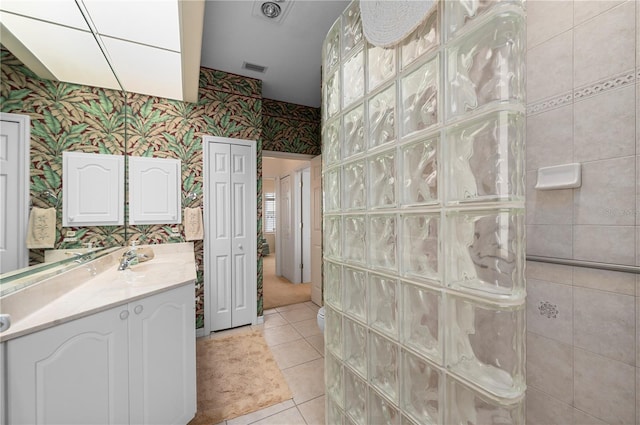 bathroom with visible vents, wallpapered walls, vanity, tile patterned flooring, and walk in shower