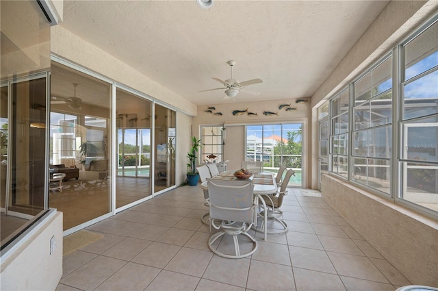 unfurnished sunroom with ceiling fan