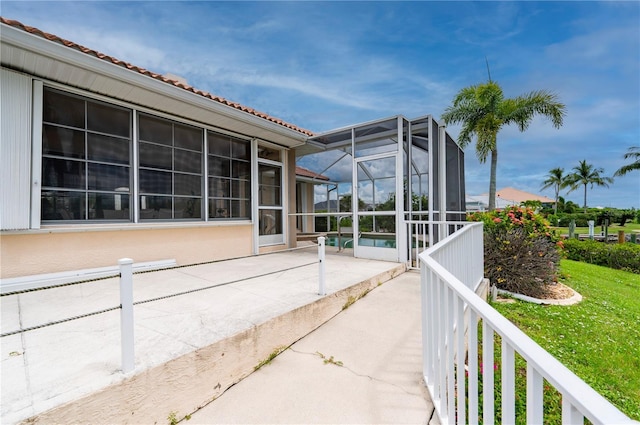 view of patio / terrace featuring glass enclosure and an outdoor pool