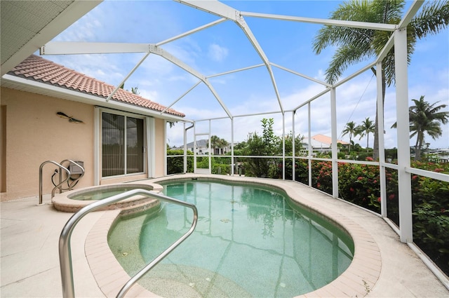 view of pool with a patio, glass enclosure, and an in ground hot tub