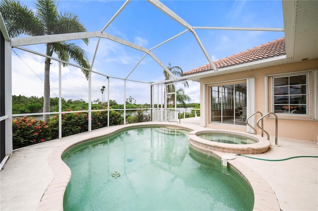 view of pool featuring a patio, glass enclosure, and an in ground hot tub