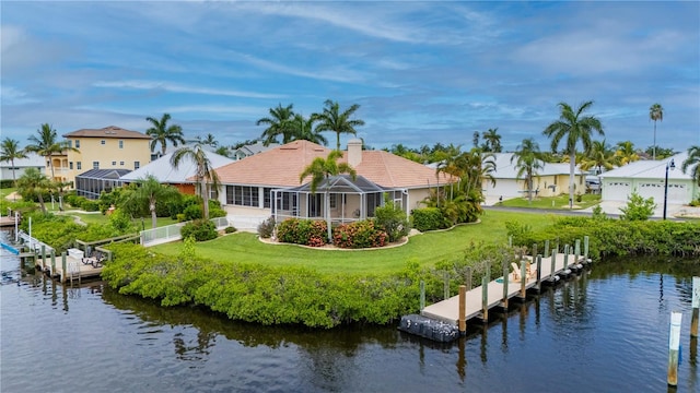 rear view of house featuring a water view, glass enclosure, and a yard