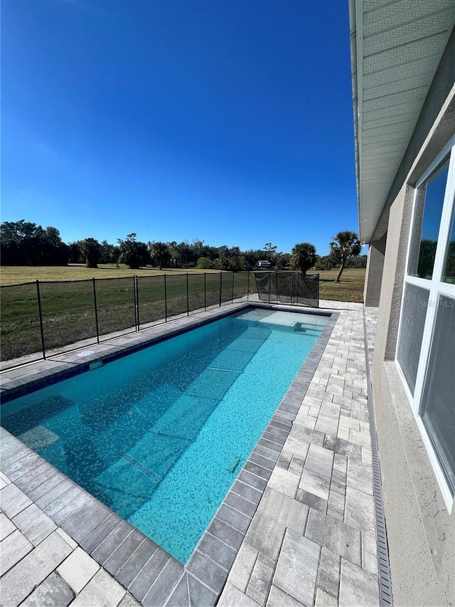 view of pool featuring a lawn