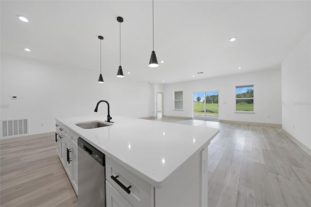 kitchen with stainless steel dishwasher, sink, decorative light fixtures, a center island with sink, and white cabinetry