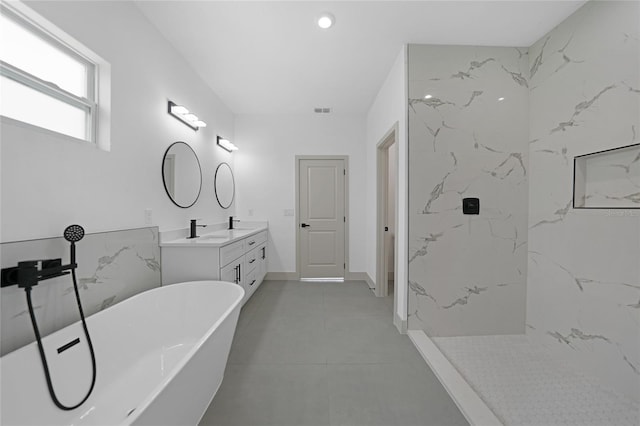 bathroom featuring a tub to relax in, tile patterned flooring, and vanity