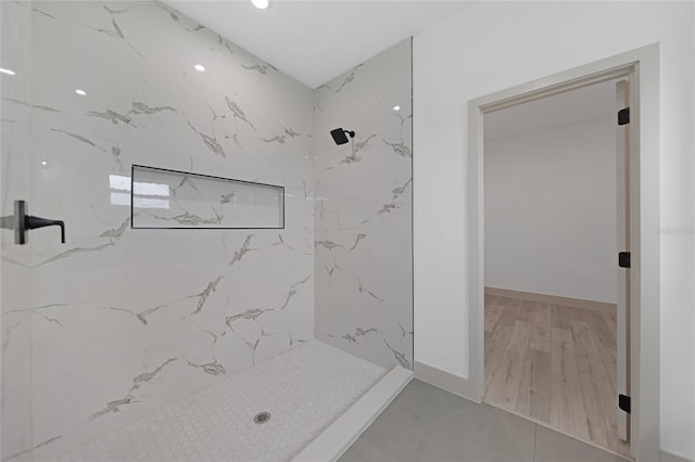 bathroom with hardwood / wood-style flooring and tiled shower