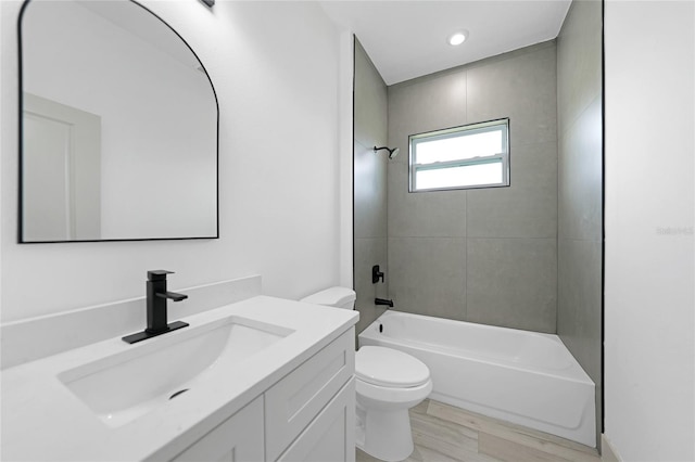 full bathroom with vanity, wood-type flooring, tiled shower / bath combo, and toilet