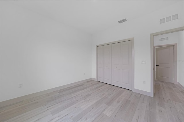 unfurnished bedroom featuring light wood-type flooring and a closet